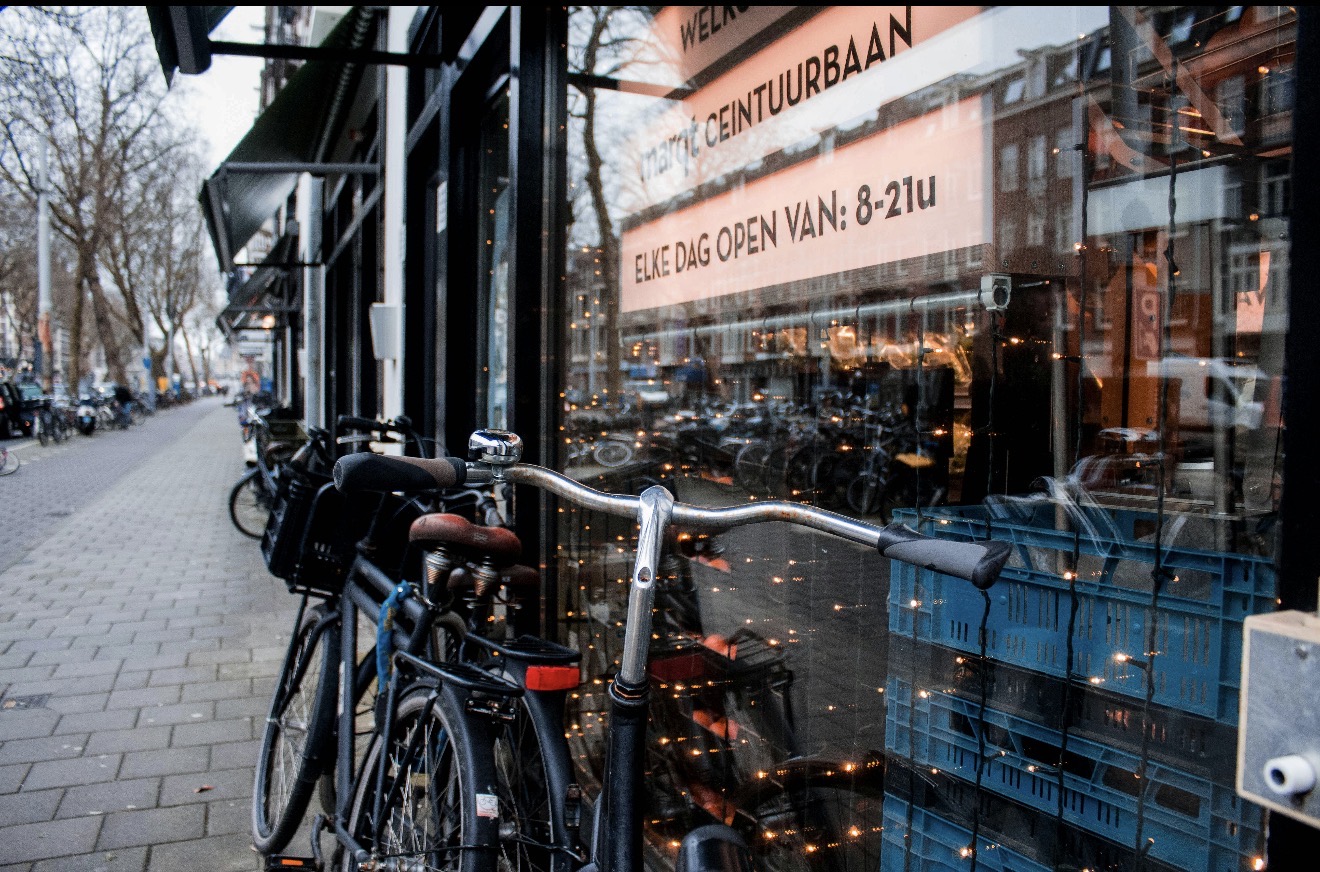 Bicicletas junto à vitrine de um estabelecimento em uma rua de Amsterdã