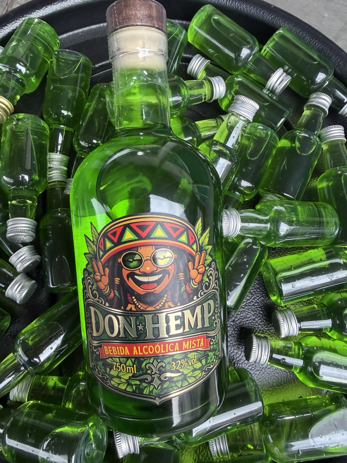 Garrafa Don Hemp verde com o rótulo original, cercada por miniaturas
